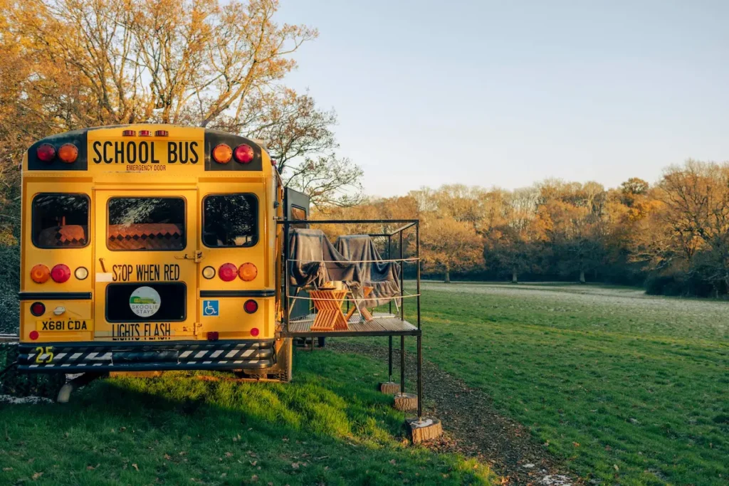 Skoolie Stays American school bus in a quiet meadow for digital detox breaks