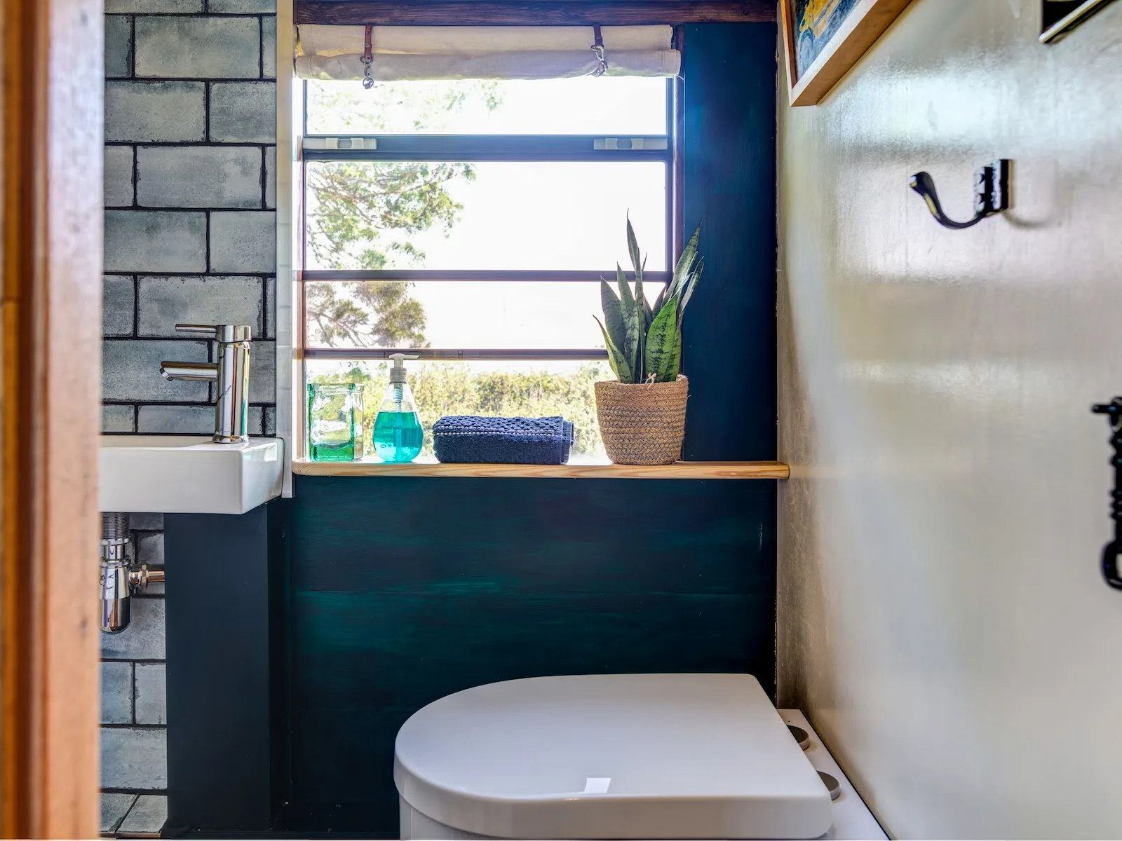 Bathroom with tiled shower and composting toilet at Skoolie Stays