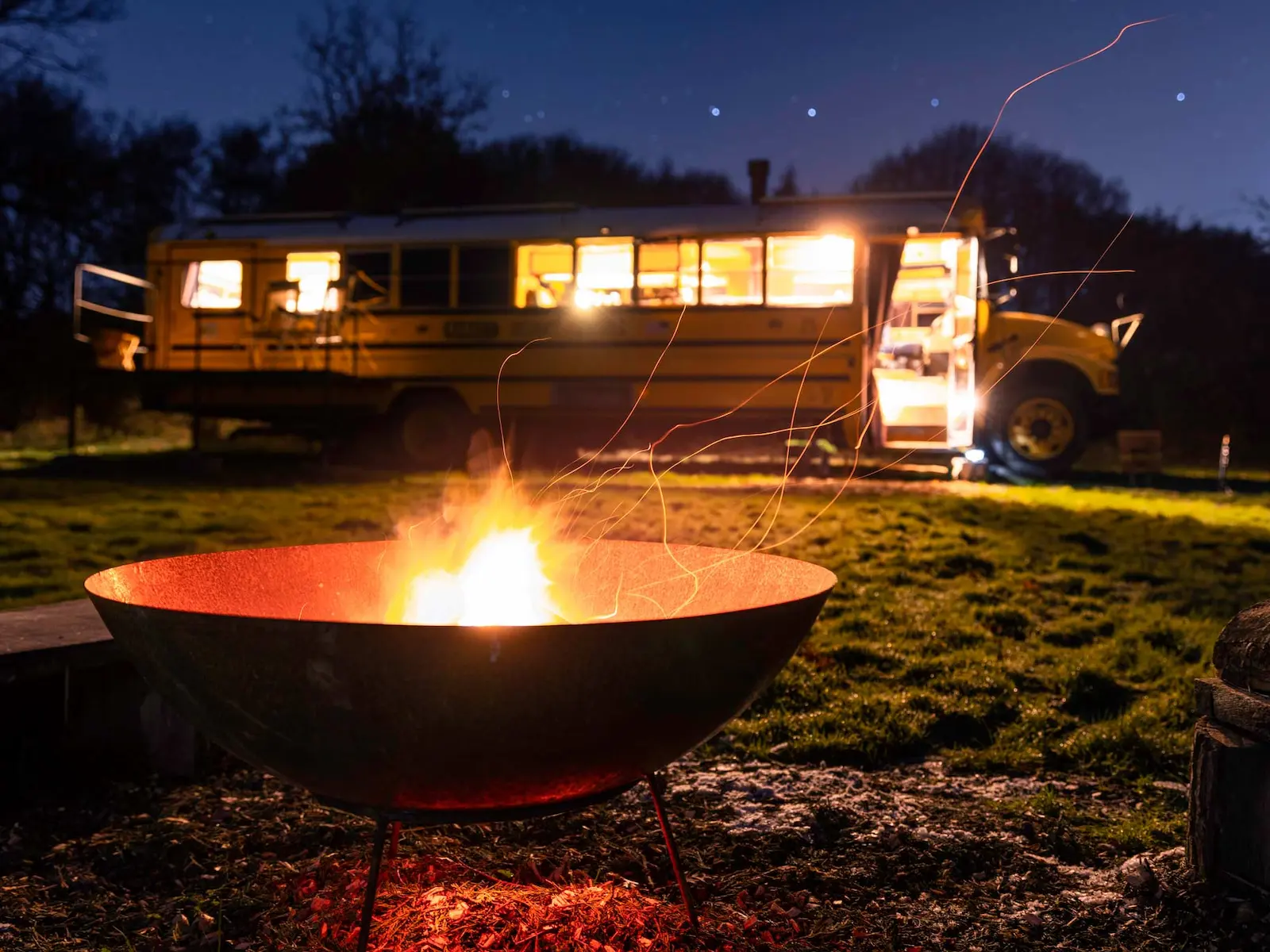 firepit and benches in the glamping field with the yellow bus