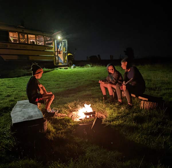 A family group enjoying private glamping in sussex with a firepit and outdoor facilities