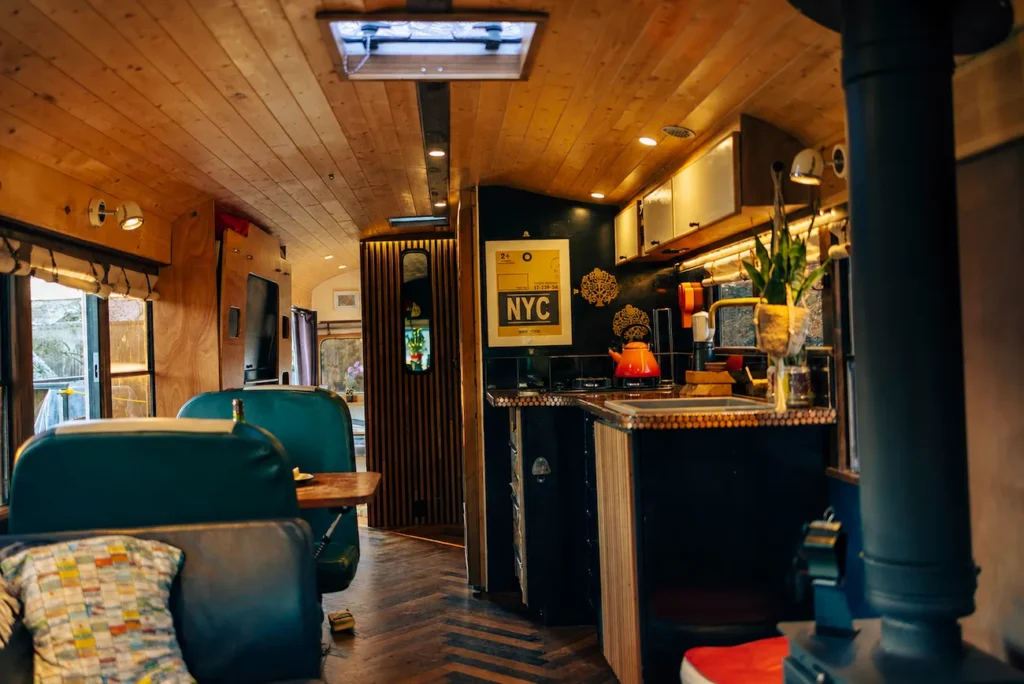 Cosy cabin-style interior of the Skoolie Stays converted school bus in West Sussex